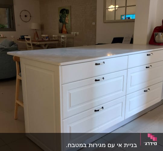 מיקסר אדום על דלפק מטבח לבן עם מגירות